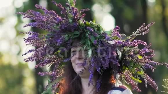 慢动作特写美丽的女孩头上戴着花圈从田野里飞花向日葵花在他身上捧着一朵花视频的预览图