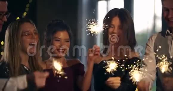 一群人燃烧着火花挥舞着火花跳舞庆祝生日和新年圣诞节友谊视频的预览图