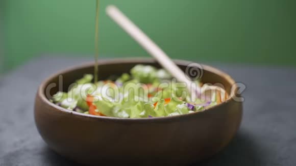 一位女士用橄榄油从各种蔬菜和蔬菜中倒入新鲜沙拉健康饮食观念素食视频的预览图