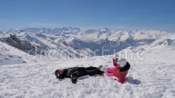 在山上的滑雪场里一对可爱的滑雪者在玩雪球视频的预览图