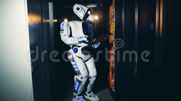 一个机器人站在一个服务器单元里在笔记本电脑上工作视频的预览图