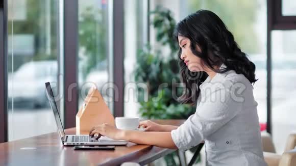 亚洲年轻女性使用笔记本电脑喝咖啡放松时间视频的预览图