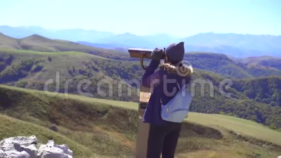 观景台上的旅游女孩用望远镜看山视频的预览图