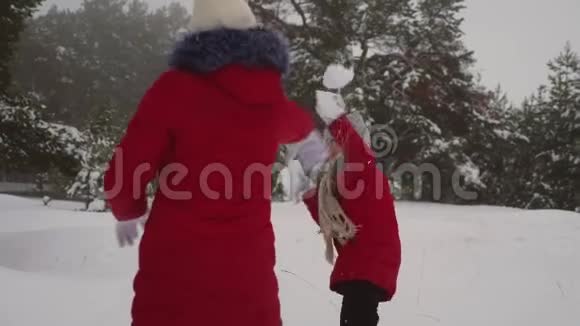 孩子们在松冬雪地公园玩雪球通过雪堆和笑声女孩在冬天在雪地里玩耍圣诞节视频的预览图