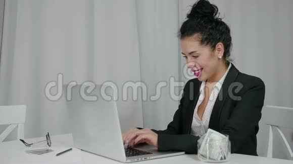 女人从笔记本电脑里掏出美元眨眼丰度概念视频的预览图