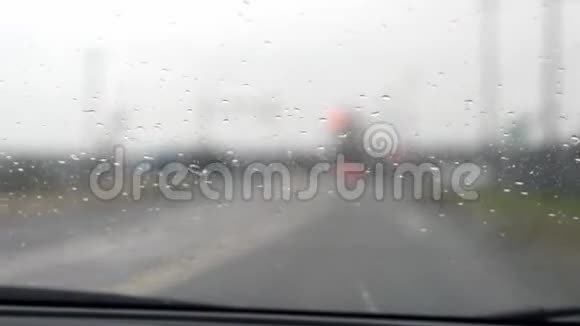 雨中驾驶失去焦点背景和大灯沉闷的一天手持视频的预览图