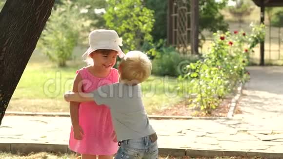 夏天一个小男孩在公园拥抱一个女孩视频的预览图