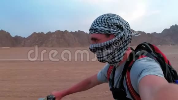 人类正在埃及沙漠骑着一辆四驱车在一个动作镜头上自射视频的预览图