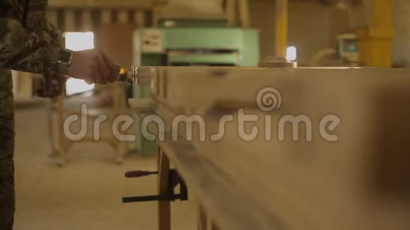 工人将胶水涂在家具车间的木结构上视频的预览图