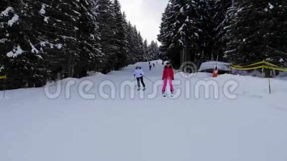 快乐女滑雪者在山上的森林坡上滑雪举起手臂视频的预览图