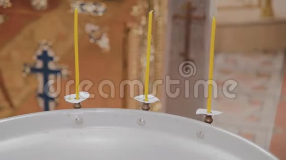 在东正教教堂用燃烧的蜡烛洗礼婴儿的字体视频的预览图