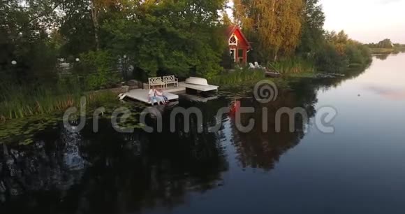 一家人坐在家里的湖边视频的预览图