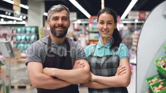 两名超市员工的画像吸引着站在店里围裙里的人微笑着看着摄像机视频的预览图