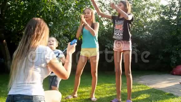 4k视频快乐的家庭在家后院追逐肥皂泡视频的预览图