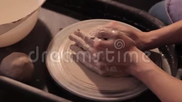 波特用陶工轮子制造产品用粘土加工成一个罐子视频的预览图