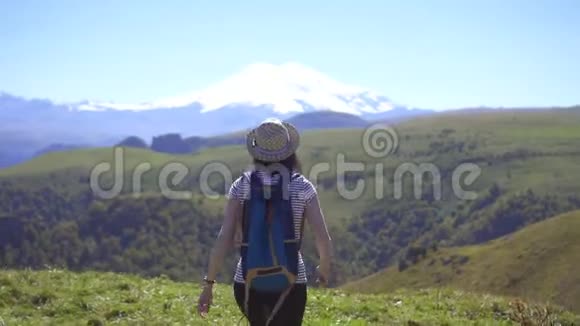 年轻的旅游女孩背着背包在山上展示成功胜利者的概念视频的预览图