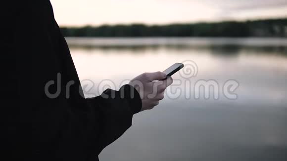 男人使用智能手机户外日落背景视频的预览图