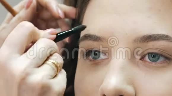特写化妆师Corrects女孩客户眉区视频的预览图