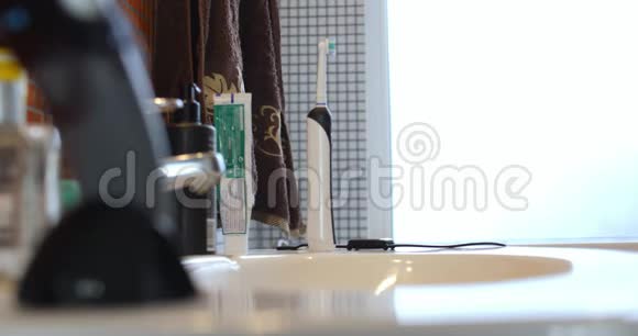 男用手在浴室里拿一把电动牙刷视频的预览图