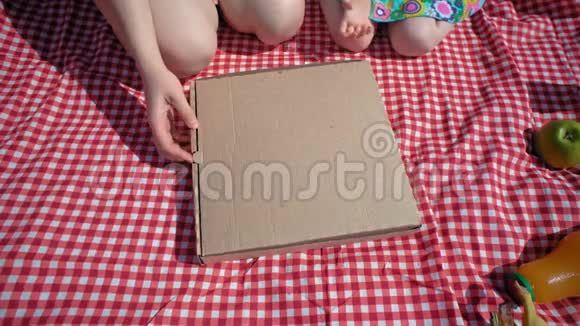 一家人打开一个纸板披萨盒然后双手拿着令人垂涎的披萨视频的预览图