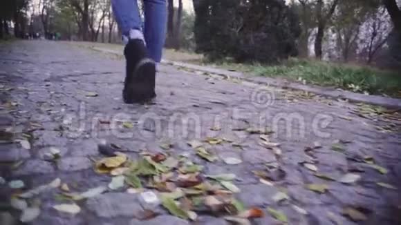 女人在公园里散步特写镜头慢动作射击视频的预览图