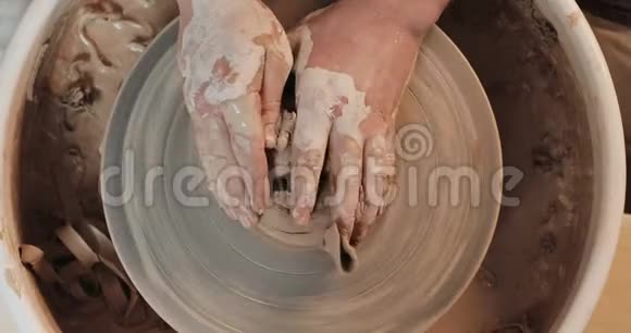 双手用专业工具在陶轮上工作在粘土板上形成浮雕上景波特在工作视频的预览图