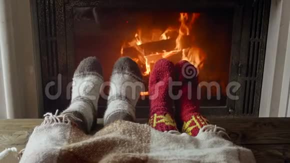 一对相爱的情侣穿着针织毛袜躺在壁炉旁边的毯子下面的视频视频的预览图