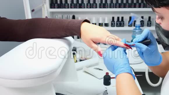 美容师在美容院给顾客的指甲涂胶视频的预览图