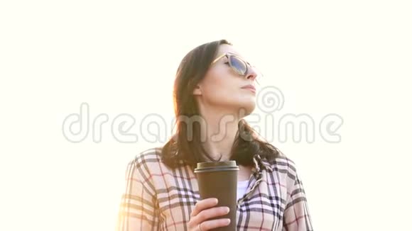 一位年轻女子手里拿着一杯咖啡的肖像慢节奏视频的预览图