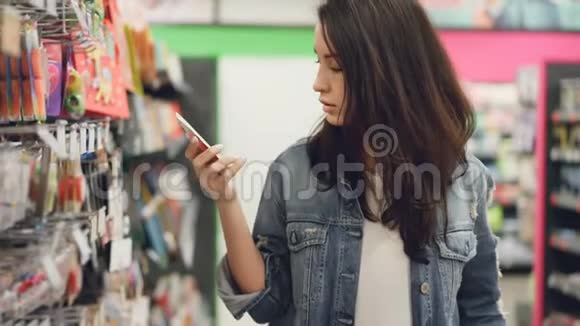 漂亮的年轻女人在超市买生日蜡烛她拿着东西看着它们比较视频的预览图