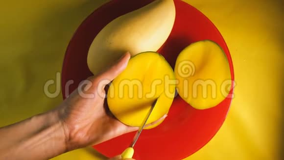 女人的手在切熟的芒果上面有一把刀视频的预览图