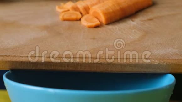 女人把切好的胡萝卜换成一个盘子用切割板特写视频的预览图