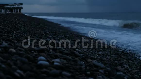 暴风雨中的海浪拍打着大海上的鹅卵石背景是雨云视频的预览图