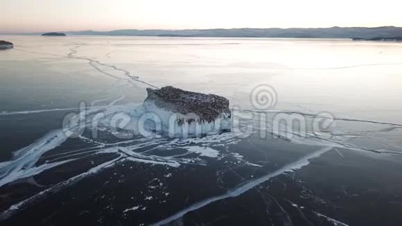 鸟瞰贝加尔湖冬天的湖有美丽的冰海岸和岛屿上的岩石俄罗斯冬季无人射击视频的预览图