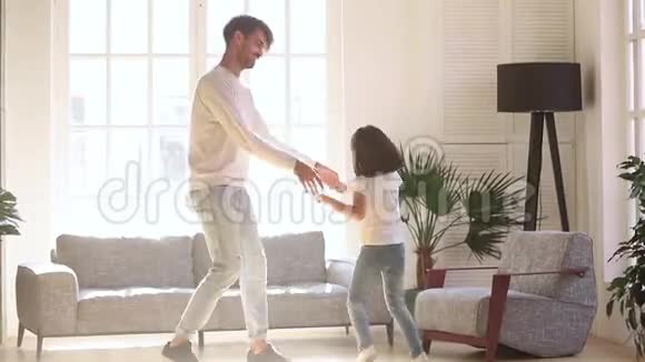 快乐的爸爸和小女儿在客厅里跳着舞视频的预览图