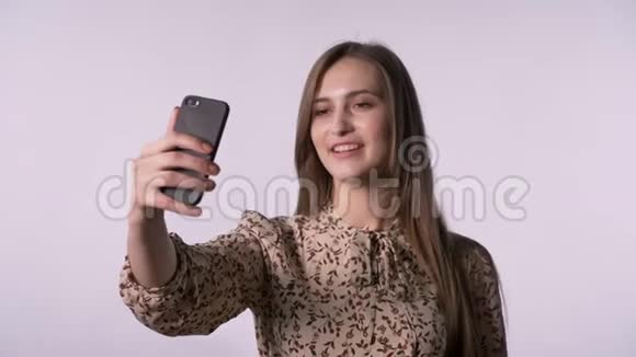 年轻漂亮的女人有智能手机视频通话交流概念白色背景视频的预览图