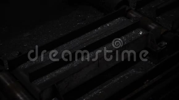 炽热的钢铁穿过黑色机器金属的生产工厂视频的预览图