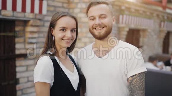 一对迷人的年轻欧裔夫妇笑着用手做心形的肖像动作缓慢视频的预览图