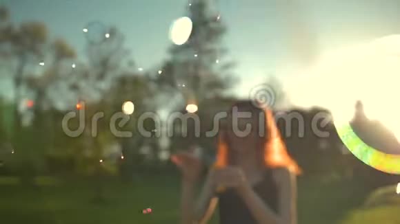 美丽的姜女肖像在公园里吹泡泡视频的预览图