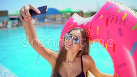 夏天漂亮的年轻女人在智能手机上自拍夏天女孩在游泳池自拍的概念视频的预览图