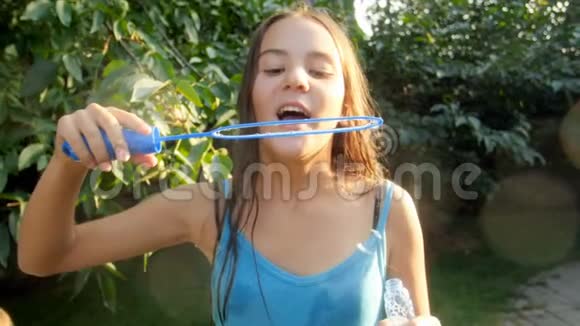 阳光明媚的一天女孩在公园里吹肥皂泡视频的预览图