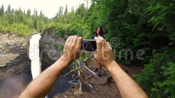 女子在瀑布附近拍照视频的预览图