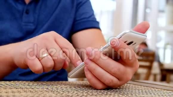男子手持智能手机在咖啡厅视频的预览图