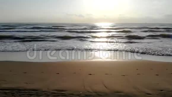 海滩上的日出海滩上的快速运动相机模仿海滩上的车在海波的后面视频的预览图