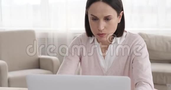 女商人一边喝咖啡一边用笔记本电脑视频的预览图
