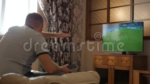 休闲科技体育娱乐和人的概念遥控观看足球或足球比赛的人视频的预览图