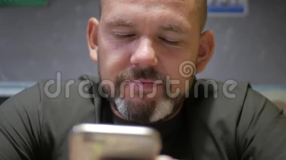 胡子青年休闲男用手机笑的开心年轻健康的男人在智能手机上微笑视频的预览图