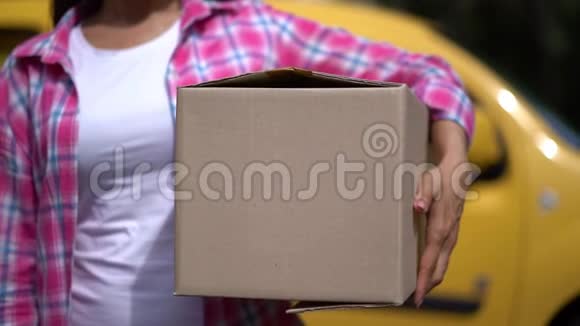 微笑的女人随便拿包裹显示OK标志视频的预览图
