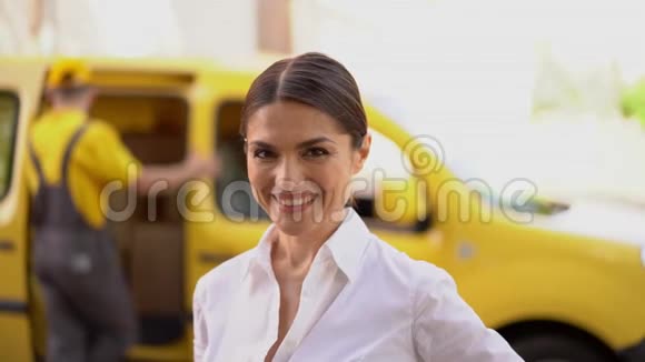 微笑的女商人正竖起大拇指后台模糊的送货车和快递视频的预览图