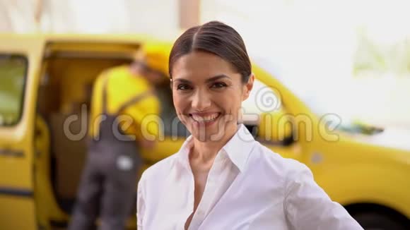 微笑的女商人正竖起大拇指后台模糊的送货车和快递视频的预览图